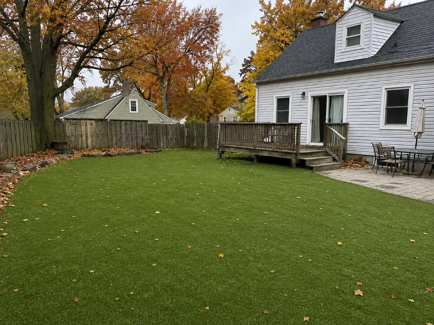 Completed residential backyard artificial turf installation with a clean green play surface
